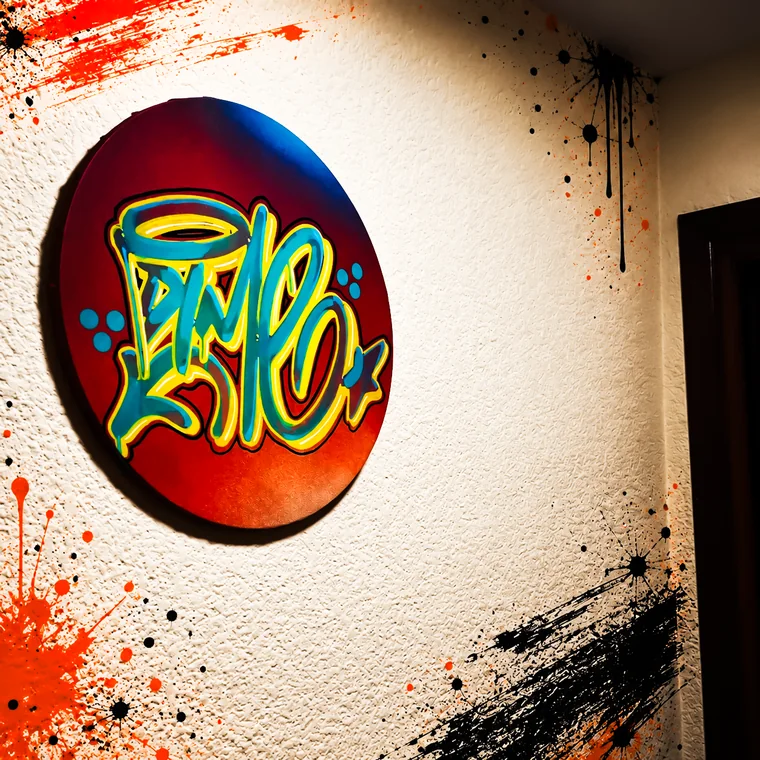 Lienzo redondo con lettering de graffiti colgado en una pared